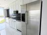 Kitchen featuring white shaker-style cabinetry, dark stone countertops, stainless steel side-by-side refrigerator, matte black gooseneck faucet, and l