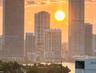 Urban skyline featuring high-rise buildings and waterfront proximity at sunset