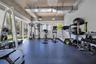 Industrial-style space featuring exposed concrete ceilings, floor-to-ceiling windows, and impact-resistant rubber flooring