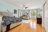 Spacious room featuring wood-finish flooring, crown molding, double-pane windows, and a central ceiling fan with integrated lighting