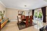 Dining area featuring polished large-format floor tiles, crown molding, a modern linear chandelier, and sliding glass doors to the exterior