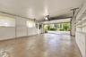 Enclosed garage featuring concrete flooring, built-in wall shelving, integrated cabinetry, and automatic overhead door opener