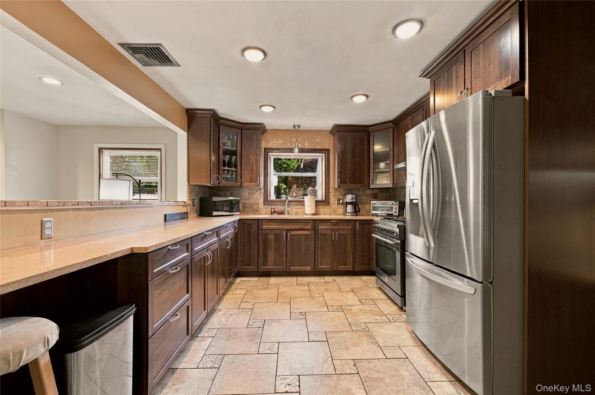 Gourmet kitchen with wood cabinets, stainless steel appliances, and recess lighting