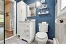 Updated primary bathroom with ceramic tile floor and glass tile walls in shower