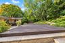 Stone-paved patio area with stone-retaining wall features and mature landscaping
