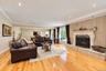Living area featuring wood-finish flooring, recessed lighting, crown molding, and a floor-to-ceiling brick fireplace with an ornate stone mantel