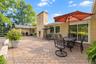 Spacious brick patio featuring a masonry chimney, sliding glass doors, and light-colored brick exterior siding