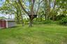 View of grassy yard with a shed