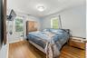 Primary bedroom with hardwood floors and 2 windows