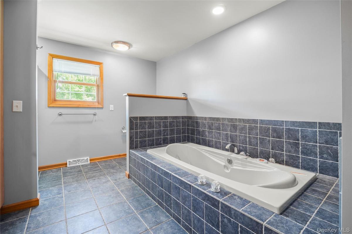 Full bath with a garden tub and tile patterned floors
