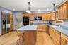 Kitchen with a kitchen breakfast bar, light wood-style flooring, decorative backsplash, and recessed lighting