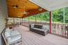 Wooden terrace featuring outdoor dining area, outdoor lounge area, and a ceiling fan