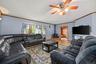 Living area featuring a pellet stove, wood finished floors, ceiling fan, and ornamental molding