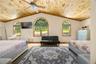 Bedroom with multiple windows, wood finished floors, lofted ceiling, wooden ceiling, and crown molding
