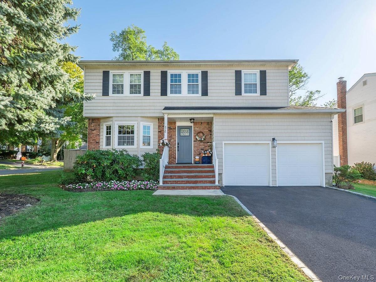 Front of home, driveway and 2 car garage with high ceilings