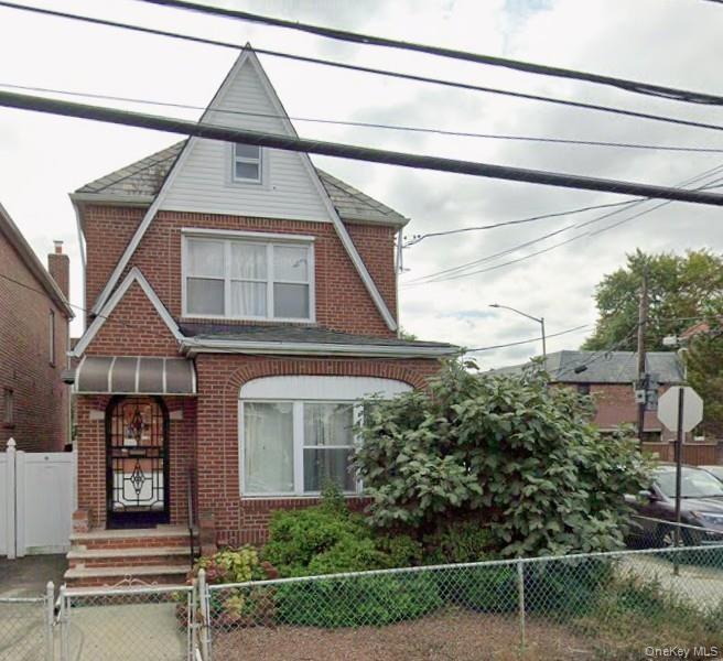 Brick exterior featuring a steep-pitched gable roof, front entrance awning, arched masonry detailing, and white siding accents