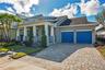 Front elevation with paver driveway, two car garage with EV charging, and covered front porch.