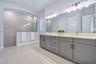 Primary bath with a Carrara Marmi quartz double vanity, extra drawer storage, and a large walk in shower.