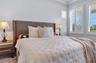 Primary bedroom retreat with room for a king bed and sitting area, plush carpet, and plantation shutters.