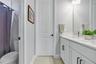 Full bath with shower and tub combination and quartz vanity.