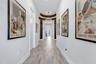Gallery style entry hallway with wood look plank tile, wide baseboards, and crown moulding welcoming you inside.
