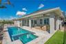 Rear exterior with private heated salt water pool and covered extended lanai. Florida outdoor living in Lake Nona, Orlando.