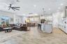 Bright great room open to the kitchen with high ceilings, ceiling fan, and plantation shutters. Easy everyday living in Laureate Park, Lake Nona.