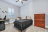 Secondary bedroom with ceiling fan, carpet, and a built in closet system.