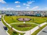 Landscaped neighborhood park with winding walking paths in Laureate Park.
