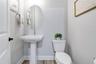 Convenient half bath with pedestal sink and modern finishes.