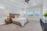 Primary bedroom with a tray ceiling and plenty of natural light, privately positioned in the split bedroom floor plan.