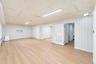 Interior space featuring vertical wood-paneled walls, wood-finish flooring, recessed built-in shelving, and louvered double doors