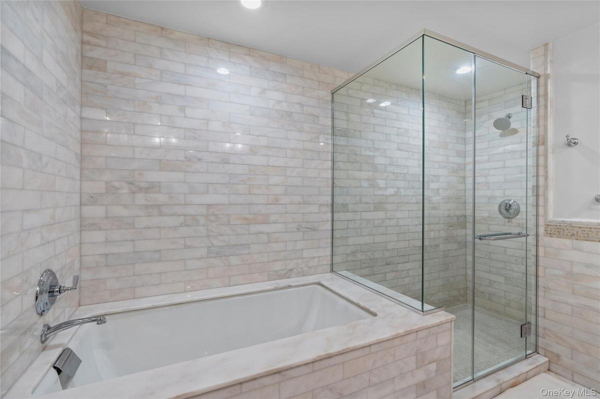 Full bathroom featuring a shower stall and a bath
