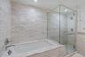 Full bathroom featuring a shower stall and a bath