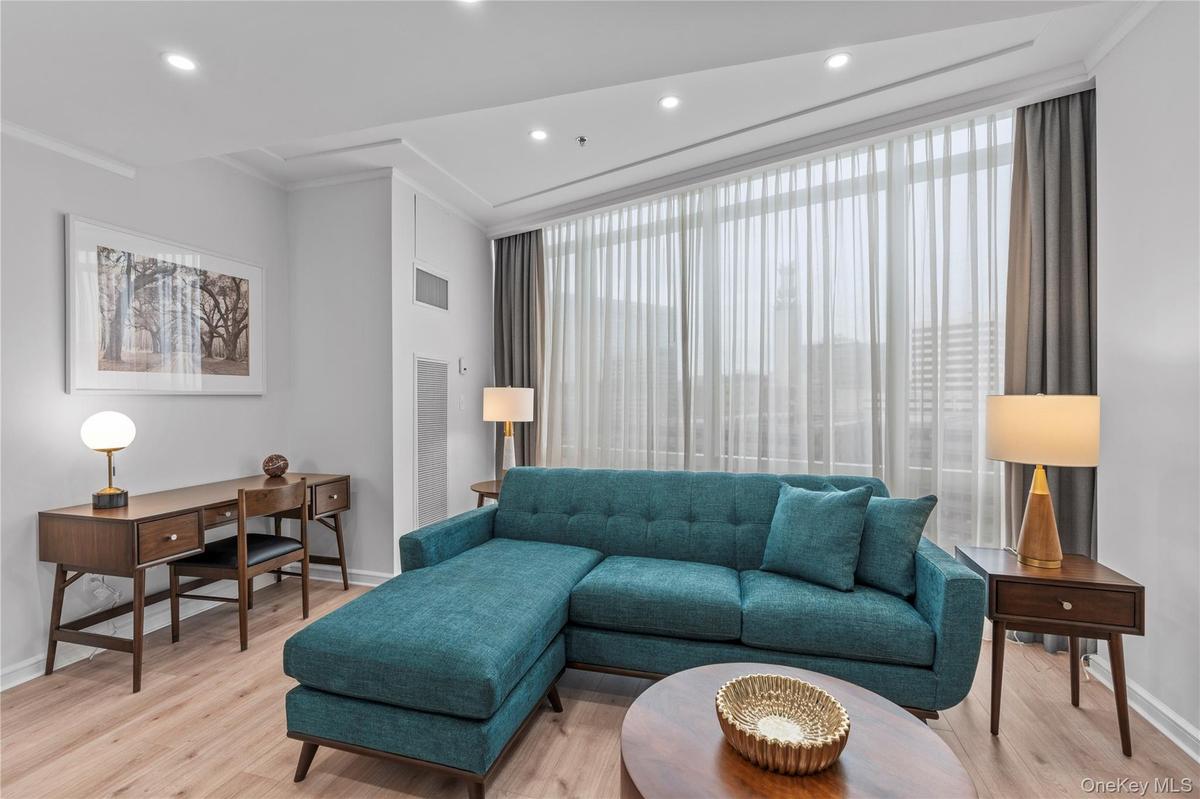 Living room featuring light wood-style floors, baseboards, visible vents, and recessed lighting