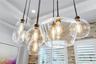 Designer glass pendant lights over the dining table add warmth and style.