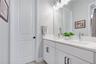 Full guest bath with quartz vanity, framed mirror, and modern fixtures.