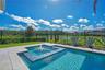 Heated salt water pool and spa with open sky and a peaceful water and conservation view.