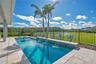 Private heated salt water pool framed by palms and a fenced yard with a water and conservation view. Lake Nona pool home living in Laureate Park, Orla