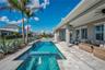Pool deck and extended lanai with room for lounging, dining, and entertaining.