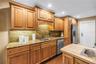 This custom kitchen features solid wood cabinetry, granite countertops, and a matching backsplash. It is equipped with updated stainless steel applian