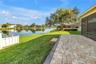 The elevated paver patio at the rear of the property overlooks a scenic grassy knoll and provides an expansive view of the lake, which serves as a nat