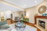 The open formal living area provides an ideal entry for guests, featuring panoramic lake views and an elegant marble fireplace.