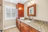 Primary bathroom featuring a second granite vanity, ample storage cabinetry, and custom-built fixtures.