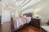 PRIMARY BEDROOM WITH ENGINEERED HARDWOOD FLOORS AND TRANSOM WINDOW