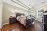 PRIMARY BEDROOM WITH DOUBLE TRAY CEILING AND SLIDING DOORS OUT TO THE POOL