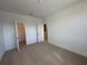 Open-concept living space featuring large-format tile flooring, recessed ceiling lighting, a dedicated kitchen island, and sliding glass patio doors