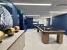 Recreation room featuring large-format tile flooring, recessed linear lighting, navy-toned walls, and a built-in refreshment counter