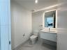 Contemporary bathroom featuring a floating white vanity, polished large-format tile flooring, wall-to-wall decorative tile backsplash, and a modern ba