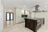 Kitchen featuring an expansive center island with stone countertop, stainless steel professional-grade appliances, built-in cabinetry, polished stone 